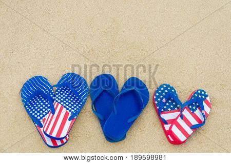 Patriotic USA background with flip flops on the sandy beach