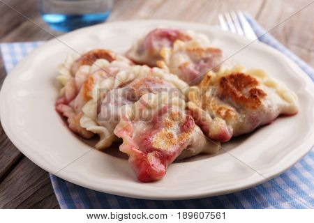 Traditional Polish dumplings Pierogi ruskie with sour cherry on a rustic table