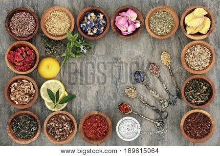 Herb tea selectionn in wooden bowls and old spoons with strainer, teas also used in natural alternative medicine.
