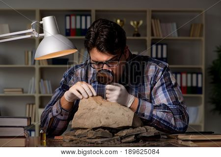 Archeologist working late night in office