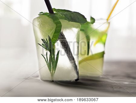 two glasses with fresh cocktail made of ice on concrete table. concept