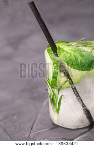 glass with fresh cocktail made of ice on concrete table. concept. vertical