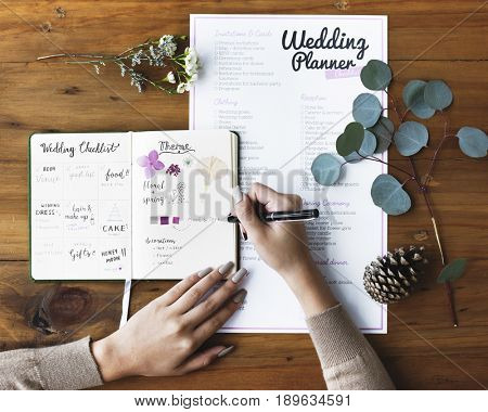 Hands Checking on Wedding Planner Notebook