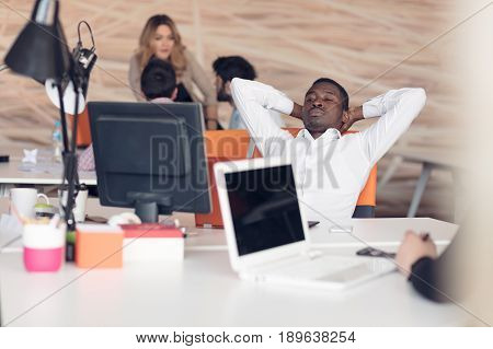 Young African-American business man taking a break at his desk.