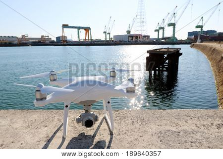 KAGAWA, JAPAN - MAY 28, 2017: White drone Dji Phantom4Pro stay on concrete blocks for protection of port and ready to fly.
