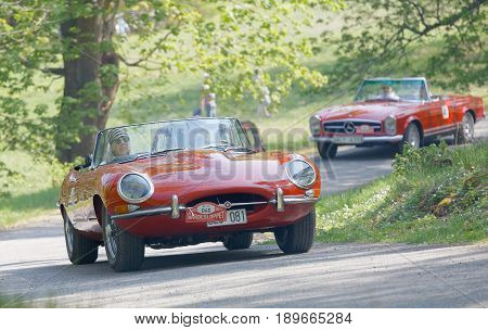STOCKHOLM SWEDEN - MAY 22 2017: Red Jaguar E-Type classic car from 1965 driving on a country road in the public race Gardesloppet in the forests at Djurgarden Stockholm Sweden. May 22 2017