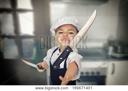 Funny portrait of a six years girl dressed as a cook throwing a knife