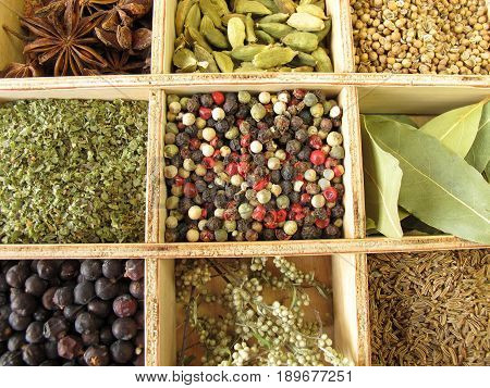 Wooden box with pepper, marjoram, coriander and other spices