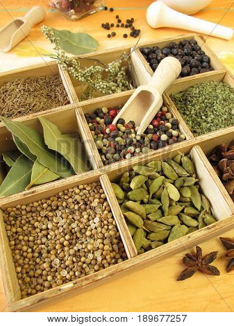 Wooden box with pepper, marjoram, coriander and other spices