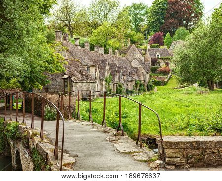 Old footbridge and  traditional Cotswold cottages,   Bibury,  England, UK.