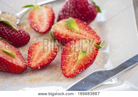 strawberries cut with sugar and mint close up