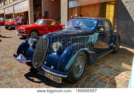 Saint Moritz Switzerland AUG 20 2010: View on navy and red color classic old fashion style classical Alfa Romeo cars at street exhibition. Italian classic cars. Luxury and style. Swiss Matterhorn