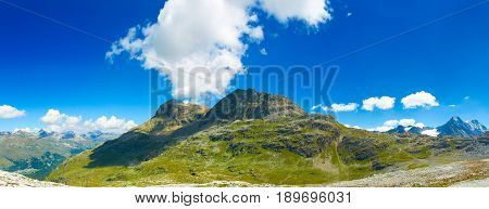 Beautiful panoramic view on Alps Alpine green mountains amazing blue sky and clouds. Touristic sightseeing viewpoint. Cable way station next to Corvatsch. Swiss holidays vacations tours. Matterhorn