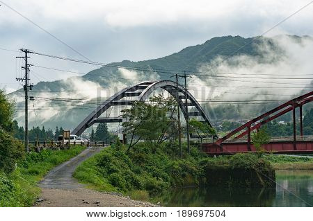 Landscape Of Bridge With Mountain And Low Clouds On The Background