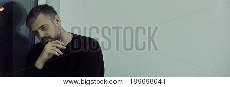 Man Smoking By Window