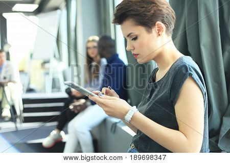 Portrait young business woman using modern smartphone hands.Girl reading sms message in working process at sunny office. Horizontal blurred
