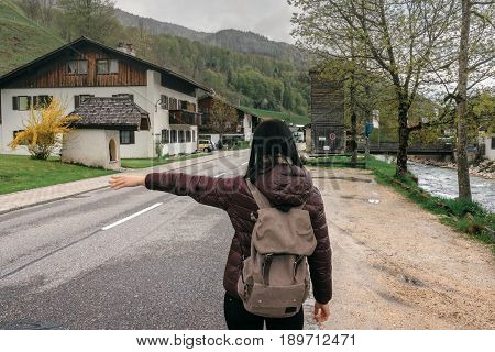 Germany. Ramsau. Travel woman hitchhiking.  Ramsauer Ache river
