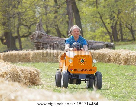 STOCKHOLM SWEDEN - MAY 21 2017: Smiling boy and granpa driving a orange soapbox car downhill on a field in the race Gardesloppet at Djurgarden Stockholm Sweden. May 21 2017