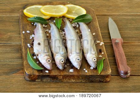 Raw fish with spices and lemon on the kitchen blackboard