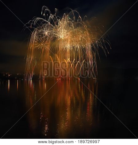 Beautiful colorful fireworks on the water surface with a clean black background. Fun festival and contest of Firefighters Brno Dam - Czech Republic.
