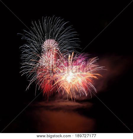 Beautiful colorful fireworks on the water surface with a clean black background. Fun festival and contest of Firefighters.
