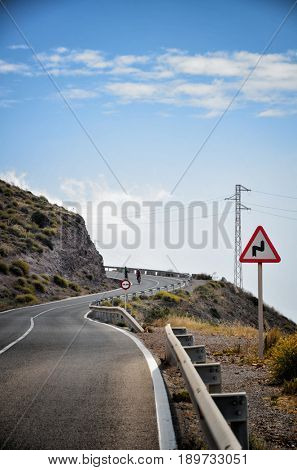 Warning sign in a red triangle on a mountain road