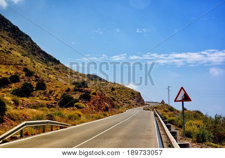 Warning sign in a red triangle on a mountain road