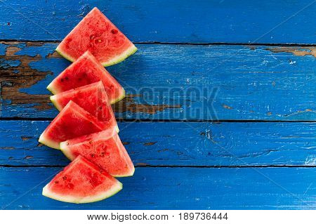 Sliced watermelon Top View. Many slices on an old rustic blue table. Side composition with copy space. Food Backrgound.