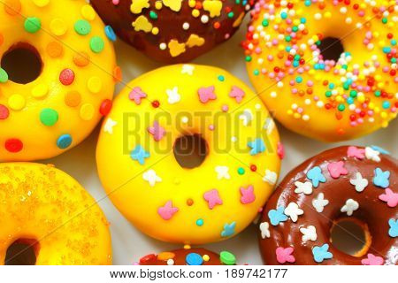 Yellow and brown donuts on a white plate