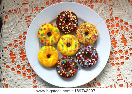 Yellow and brown donuts on a white plate