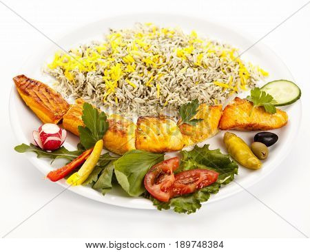 Studio closeup shot of a grilled salmon kebab with rice and herbs on a plain plate on white background. Healthy dietary concept with essential nutrients and long-chain polyunsaturated fatty acids.