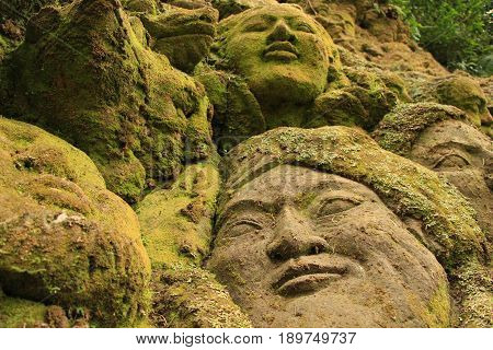 Green Moss covered stone sculptures in Ubud, Bali.