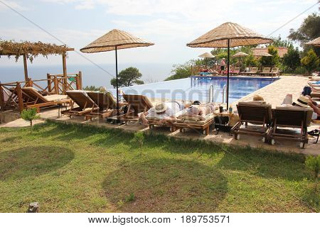 30TH MAY 2017, KABAK, TURKEY : English tourists having a swim and cooling off in an infinity pool at the olive garden in Kabak in Turkey, 30th may 2017
