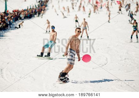 Sheregesh, Kemerovo region, Russia - April 16, 2016: Grelka Fest is a sports and entertainment activity for ski and snowboard riders in bikini. man goes down on a snowboard