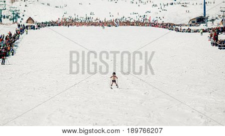 Sheregesh, Kemerovo region, Russia - April 16, 2016: Grelka Fest is a sports and entertainment activity for ski and snowboard riders in bikini.child descends from the mountain in shorts
