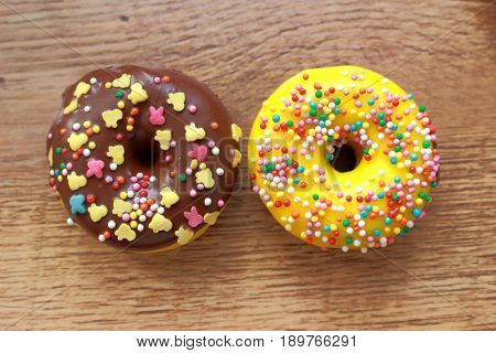 Two assorted donuts on a wood background