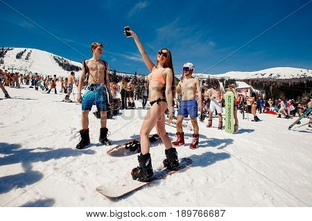 Sheregesh, Kemerovo region, Russia - April 16, 2016: Grelka Fest is a sports and entertainment activity for ski and snowboard riders in bikini.group of snowboarders friends in swimsuits.
