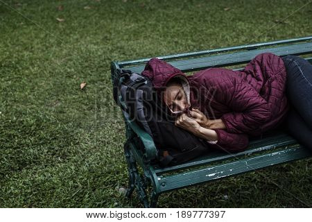 Homeless Adult Woman Sleeping on Bench in The Park