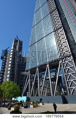 London UK - May 13 2015: Business people have a lunch break outside 122 Leadenhall Street tower and Lloyd's building in City of London UK. Both designed by the awarded British architectural firm Rogers Stirk Harbour and Partners.
