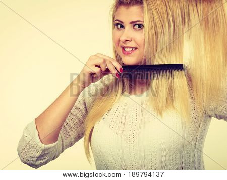 Blonde Woman Holding Hair On Clothes Hanger