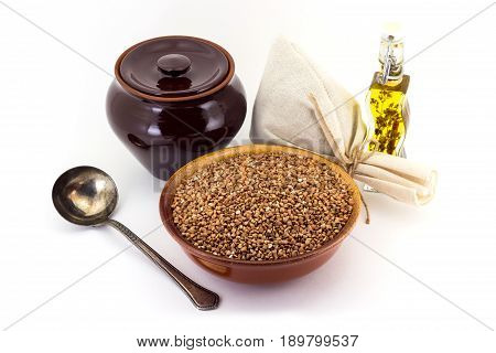 The Composition Of The Buckwheat Groats In A Clay Pial Next To A Clay Pot And A Copper Spoon,