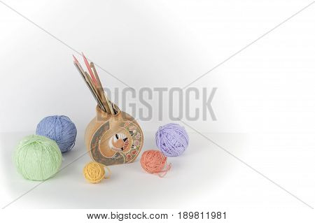 Colored yarn on a white background. Skeins of wool yarn for knitting. Balls of wool of different colours for handmade knitting on a wooden background with copy space for ad