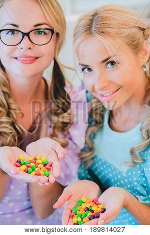 two happy women arm in arm in the kitchen dressed in aprons