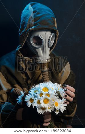 the photo of girl in gas mask on grey background c daisies