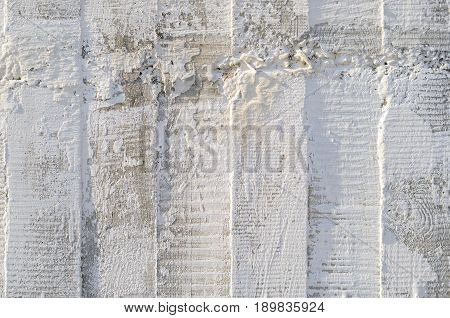 Texture of wooden formwork stamped on a raw concrete wall as background. Vertical strips from formwork
