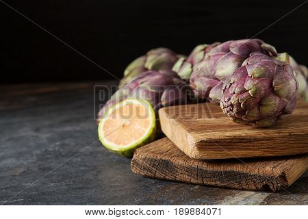 Baby Ripping Organic Artichokes With Lemon. Food For A Vegan And