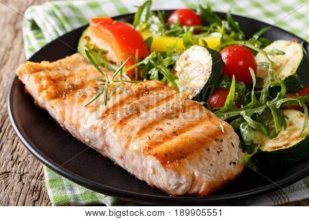 Tasty Fillet Of Grilled Salmon And Vegetable Salad With Arugula Close-up. Horizontal