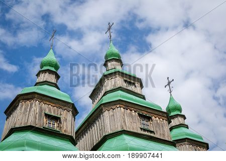 An old traditional wooden Ukrainian church against the sky. National architecture. National Museum Pirogovo in the outdoors near Kiev. Ukraine.