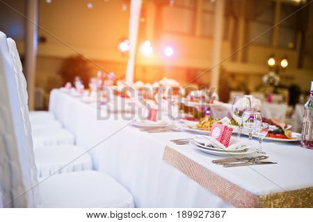 Table Of Newlyweds With Dises And Chairs.