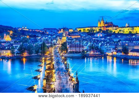 View of Charles Bridge, Prague Castle and Vltava river in Prague, Czech Republic during blue hour. Star filter effect.